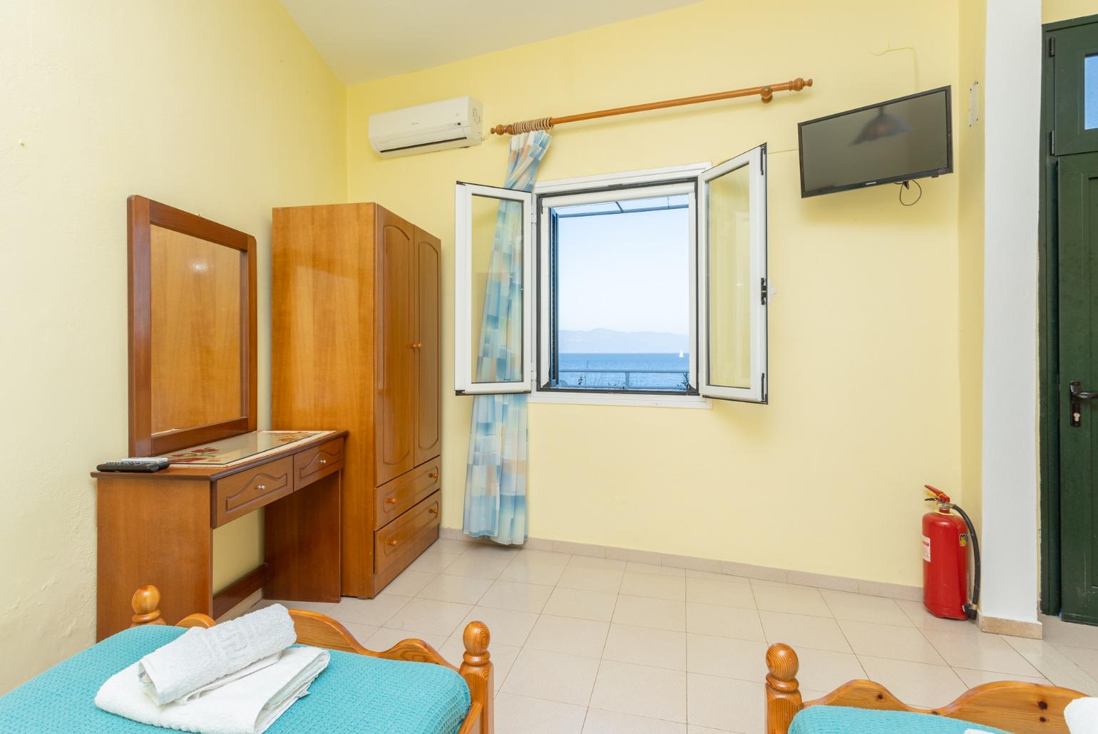 Open-plan studio with twin beds, dining area, kitchen, A/C, WiFi internet, satellite TV, and sea views