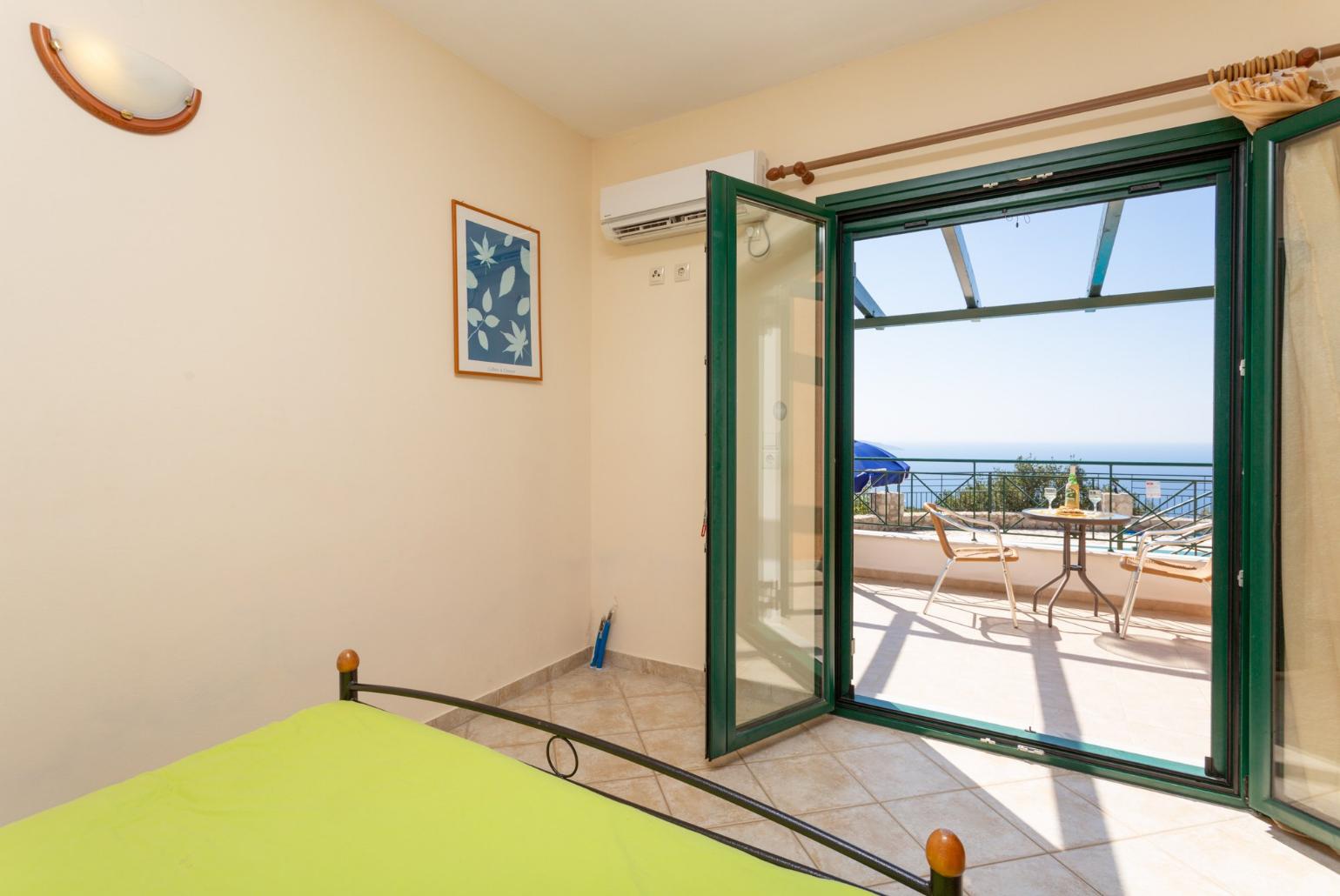 Double bedroom on ground floor with en suite bathroom, A/C, and terrace access with sea views