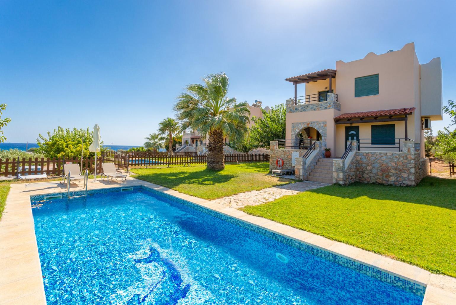 ,Beautiful villa with private pool, terrace, and lawn with sea views