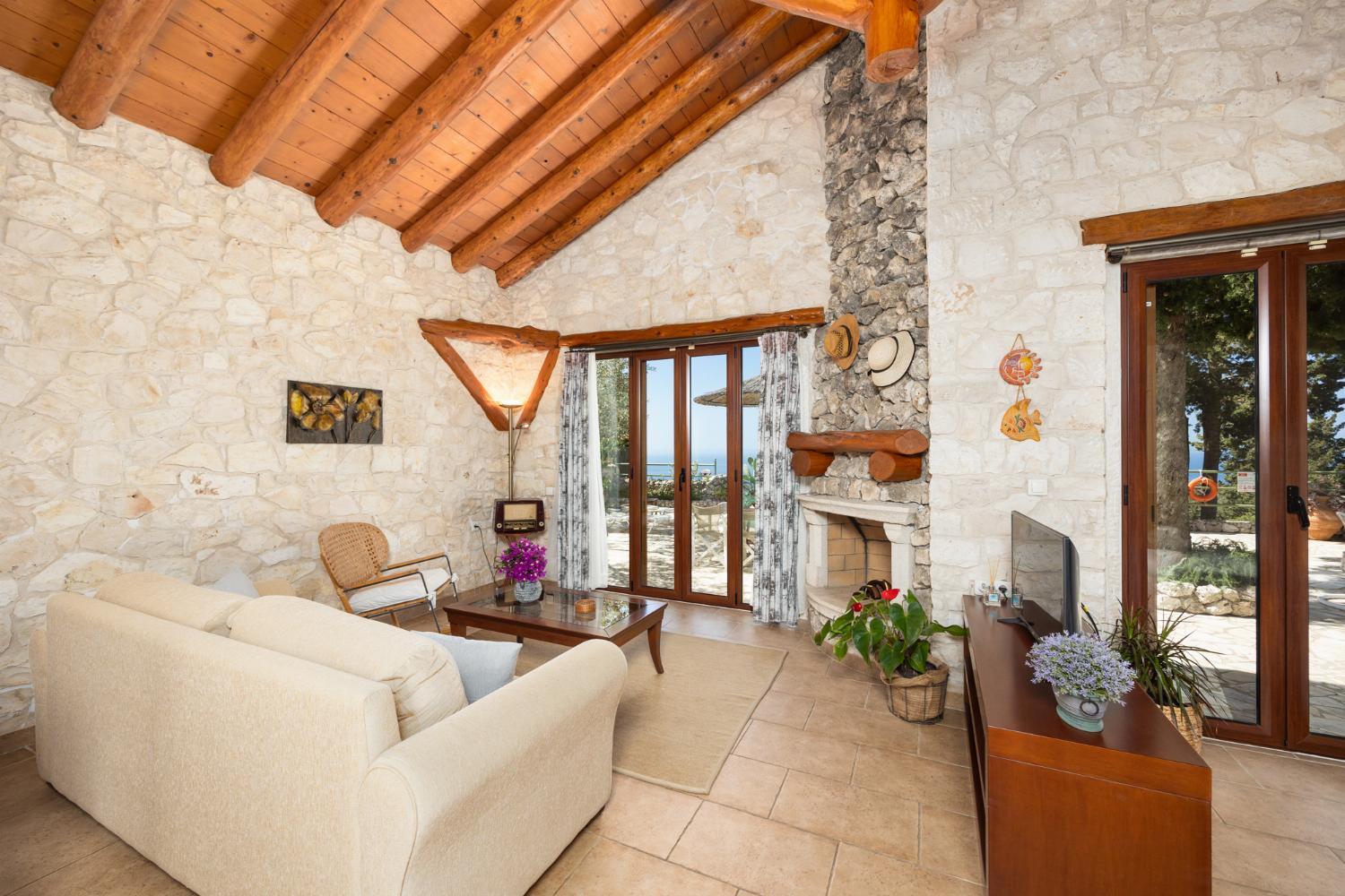 Open-plan villa with sofa, dining area, kitchen, double bed, bathroom, ornamental fireplace, A/C, WiFi internet, satellite TV, and sea views