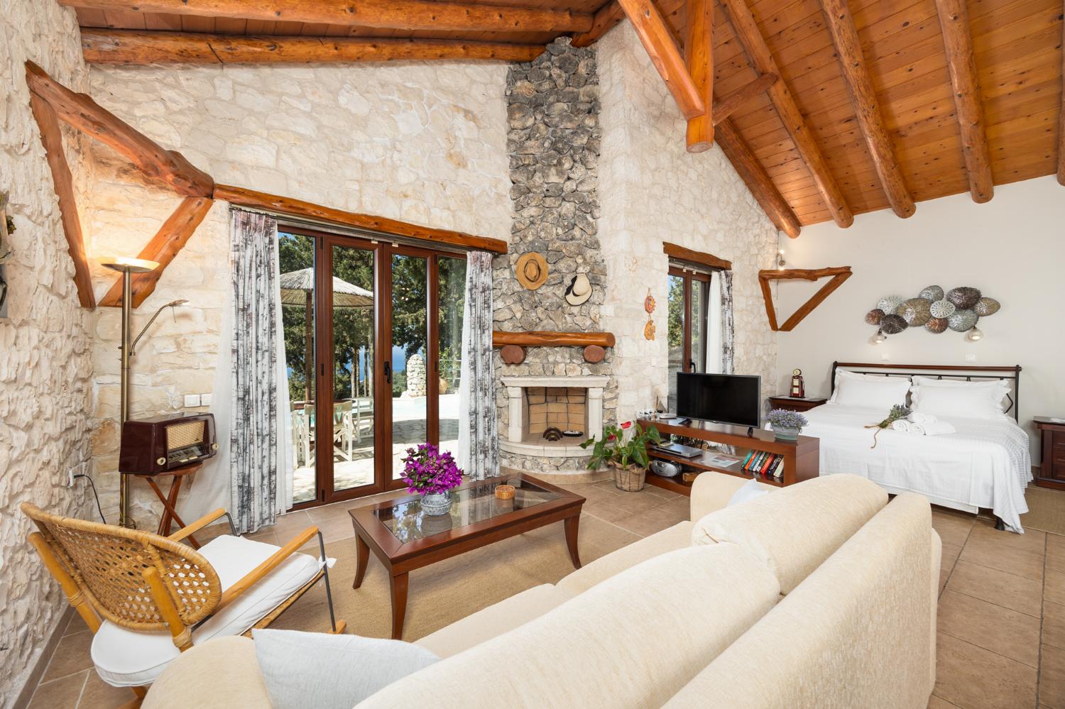 Open-plan villa with sofa, dining area, kitchen, double bed, bathroom, ornamental fireplace, A/C, WiFi internet, satellite TV, and sea views