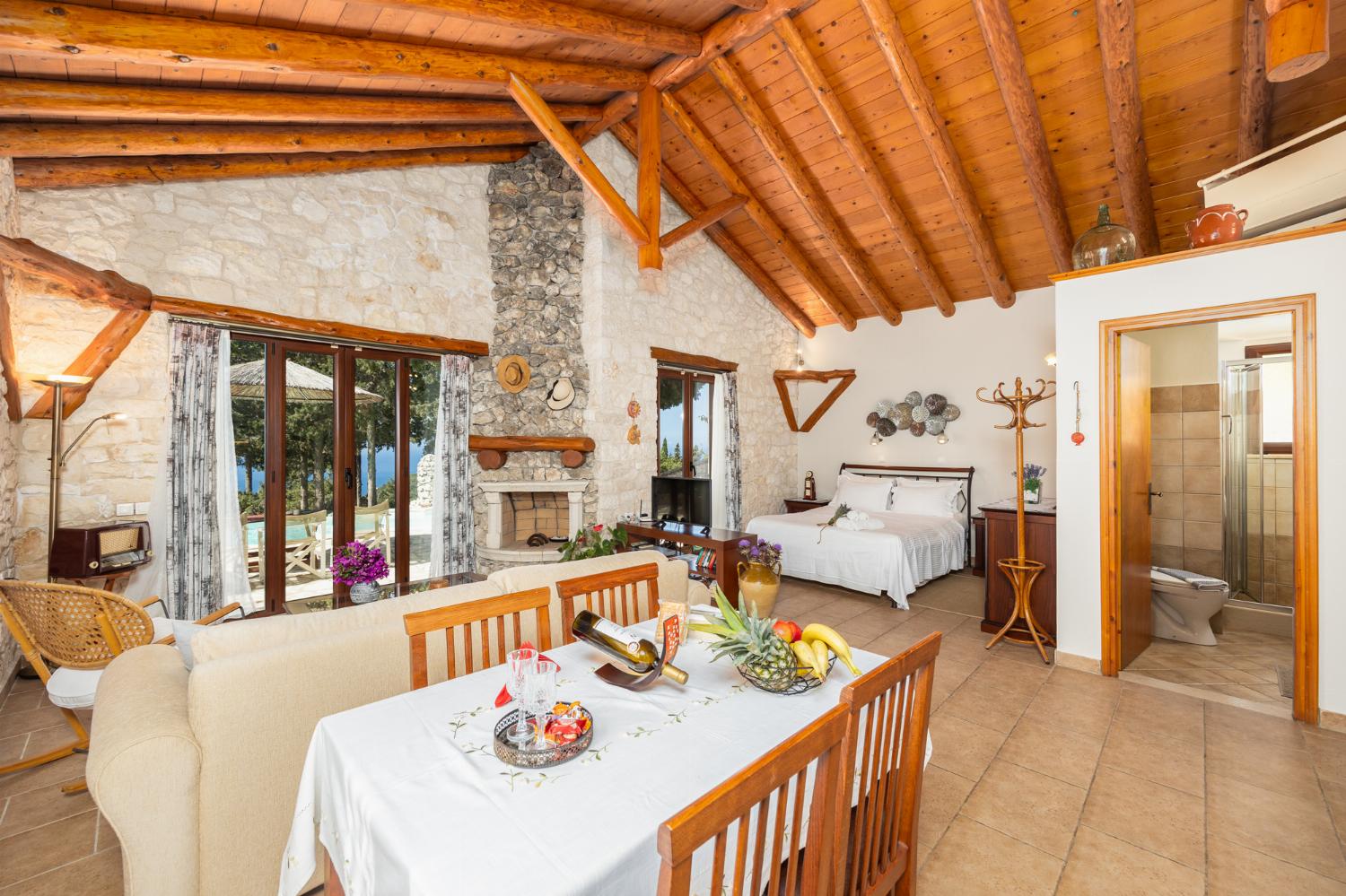 Open-plan villa with sofa, dining area, kitchen, double bed, bathroom, ornamental fireplace, A/C, WiFi internet, satellite TV, and sea views