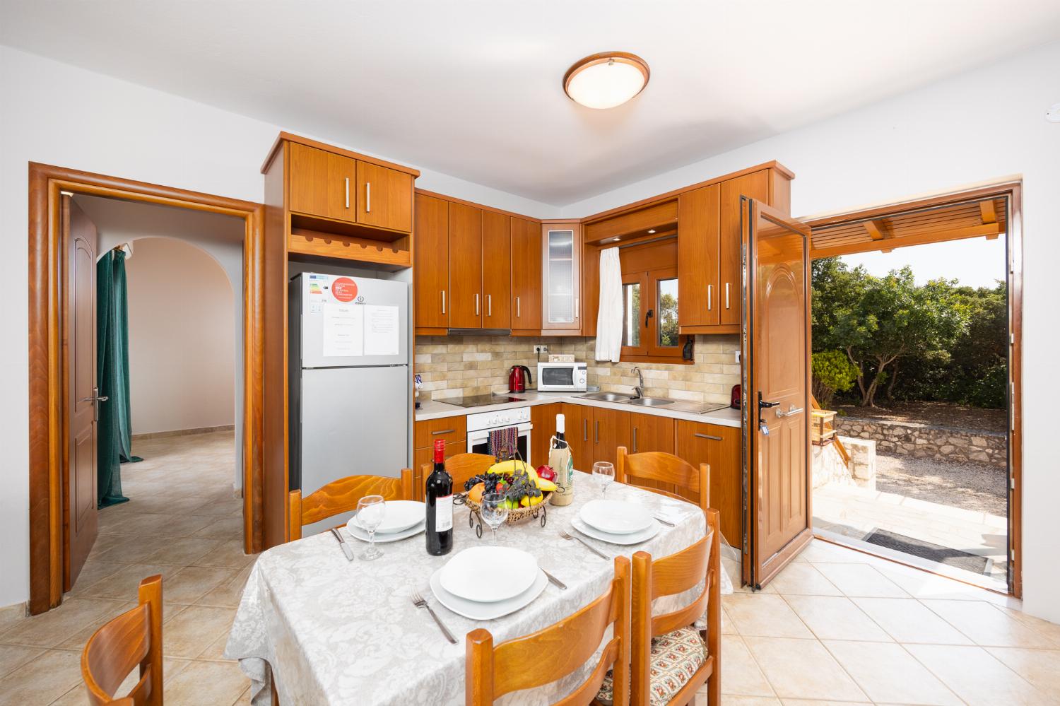 Open-plan living room with sofas, dining area, kitchen, ornamental fireplace, A/C, WiFi internet, and satellite TV